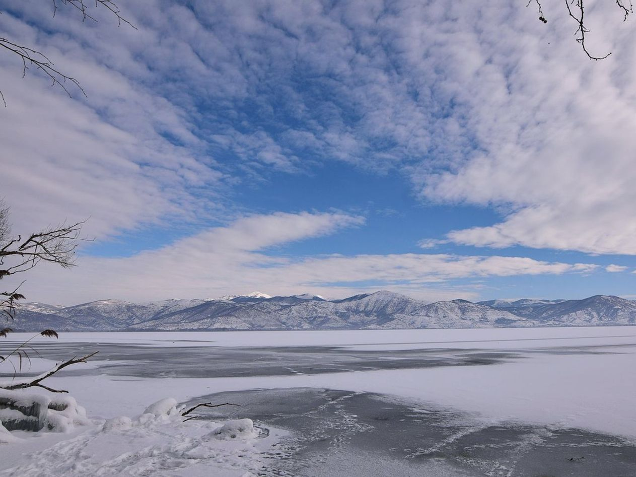 Agua tranquila del lago bajo el hielo al atardecer